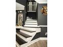 Elegant stairway with black and white accents, complemented by stylish wall decor and modern lighting at 1473 Wildwood Way, Hampton, GA 30228