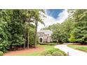 View of exterior with mature trees, landscaped yard and circular driveway leading to a brick home at 35 Inverleigh Row, Covington, GA 30014
