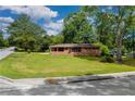Inviting brick home with expansive front lawn surrounded by mature trees on a corner lot at 3888 Lindley Cir, Powder Springs, GA 30127