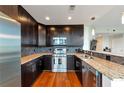 Stylish kitchen with stainless steel appliances, dark cabinetry, granite countertops, and hardwood flooring at 1080 Peachtree Ne St # 1208, Atlanta, GA 30309