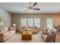 Bright living room with lots of seating, neutral walls, carpet and natural light at 173 Parkview Place Dr, Mcdonough, GA 30253