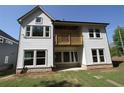 Exterior of a light gray two-story home with a small wooden balcony and large windows, and a stone foundation at 4435 Beechnut Cir, Cumming, GA 30028