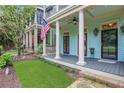 Inviting front porch with classic columns, a ceiling fan, and well-kept landscaping and front lawn at 659 Holcomb Bridge Rd, Norcross, GA 30071