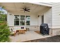 Covered patio with stylish seating, ceiling fan, and outdoor grill perfect for relaxing at 115 Ivey Way, Woodstock, GA 30188
