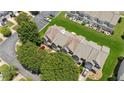 Aerial view of a townhouse community with manicured lawns, parking areas, and mature trees at 299 Azalea Cir, Cumming, GA 30040