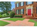 Close up of the entryway featuring a red door and brick walkway surrounded by greenery at 4045 Boles Creek Dr, Duluth, GA 30096