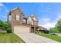 Two-story home featuring a stone facade, two-car garage, inviting curb appeal, and a well-manicured lawn at 3755 Lake Haven Way, Atlanta, GA 30349