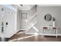 Inviting foyer with hardwood floors, a white staircase, and stylish decor setting a warm and welcoming tone at 5990 Eagle Tiff Ln, Sugar Hill, GA 30518