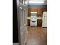 A kitchen featuring wooden cabinets, white appliances and hardwood flooring at 6470 Bedford Ln, Lithonia, GA 30058