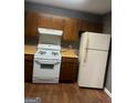 A kitchen with wooden cabinets, light countertops, and white appliances at 6470 Bedford Ln, Lithonia, GA 30058