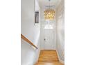 Bright entryway with hardwood floors, statement lighting, wallpaper, and classic staircase at 196 Mystic Ct, Atlanta, GA 30342