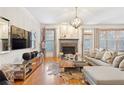 Sunlit living room with hardwood floors, fireplace, mantel, stylish décor, and large windows at 196 Mystic Ct, Atlanta, GA 30342
