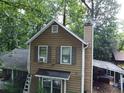 Close-up of two-story home with wood siding and a chimney at 1383 Natchez Sw Trce, Marietta, GA 30008
