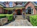 Inviting stone walkway leads to the front door, framed by elegant landscaping and brickwork at 10020 Normandy Ln, Suwanee, GA 30024