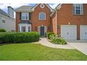 Charming brick home with a well-manicured lawn and two-car garage at 5010 Amber Leaf Dr, Roswell, GA 30076