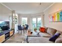 Cozy living room includes a comfortable sectional sofa, a dining table, and a balcony with views of the neighborhood at 1 Biscayne Drive Nw # 706, Atlanta, GA 30309