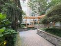 Charming outdoor common area with a wooden pergola, stone walls, and lush landscaping at 1201 River Green Nw Dr, Atlanta, GA 30327
