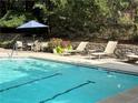 Inviting community pool with lounge chairs, patio table, and lush greenery for a relaxing experience at 1201 River Green Nw Dr, Atlanta, GA 30327