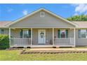 Inviting front porch with rocking chairs, leading to the entrance of a charming single-story home at 487 Laney Rd, Locust Grove, GA 30248