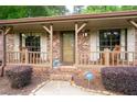 Inviting front porch with rocking chairs, brick accents, and manicured shrubs, offering a cozy outdoor space at 655 Stone Harbor Sw Pkwy, Marietta, GA 30060