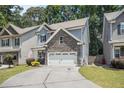 Two-story home featuring stone accents, two-car garage, and an expansive driveway at 1232 Candler Ct, Morrow, GA 30260