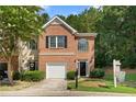 Beautiful townhome exterior with brick facade, garage, lush green lawn, and inviting curb appeal at 4221 Rogers Creek Ct, Duluth, GA 30096