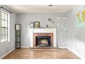Bright living room features a brick fireplace, wood floors, and natural light at 4672 Satellite Blvd, Duluth, GA 30096