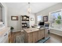 Bright home office featuring a large wooden desk, stylish decor, and an inviting atmosphere for productivity at 916 Gambino Trce, Peachtree City, GA 30269