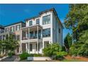 Attractive white modern home with covered front porch, balcony, and green front yard at 100 Villa Magnolia Ln, Alpharetta, GA 30009