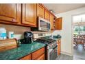 Functional kitchen featuring modern appliances, green countertops, and classic oak cabinetry at 3514 Blackberry Se Ln, Conyers, GA 30094