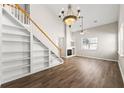 Spacious living room with fireplace, built-in shelving, hardwood floors, and a stylish chandelier at 486 Windcroft Nw Cir, Acworth, GA 30101