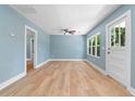 Bright living room with beautiful wood floors, a ceiling fan, and natural light at 5233 Groovers Landing Se Rd, Acworth, GA 30101