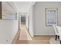 Hallway with decorative art and neutral colored walls leading to the entry door at 105 Crooked Lake Park, Villa Rica, GA 30180