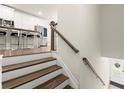 Staircase leading to a modern kitchen with stainless steel appliances and a granite island at 2227 Foley Park St, Snellville, GA 30078