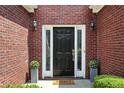 Inviting front entrance with black door, sidelights, and decorative potted plants at 200 Ennisbrook Se Dr, Smyrna, GA 30082