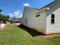 View of the backyard from the corner shows level lot and the home's white siding at 341 Brooke View Trail, Canton, GA 30115