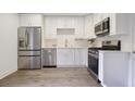 Modern kitchen features stainless steel appliances, white cabinets, and plank flooring at 5 Palace Green Place Nw, Atlanta, GA 30318