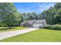 Traditional single-story home with a green lawn, attached garage, and cozy covered porch at 60 Cypress Dr, Covington, GA 30016