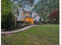 Charming, two-story home with a brick chimney, lush landscaping, and a stone walkway at 205 Pine Lake Dr, Cumming, GA 30040