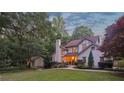 Charming, two-story home with a brick chimney and lush landscaping, all illuminated by warm light at 205 Pine Lake Dr, Cumming, GA 30040