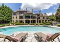 A refreshing backyard pool is surrounded by comfortable lounge chairs and lush landscaping at 170 Autry Trl, Johns Creek, GA 30022