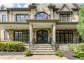 Close-up of the elegant stone front entrance with beautiful windows and custom ironwork at 170 Autry Trl, Johns Creek, GA 30022
