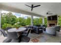 Inviting outdoor living space featuring a fireplace, comfortable seating, and a dining area at 170 Autry Trl, Johns Creek, GA 30022