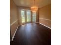 Bright dining room with elegant chandelier, hardwood floors, and large windows at 1365 Rockmart Rd, Villa Rica, GA 30180