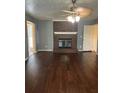 Cozy living room featuring a brick fireplace, ceiling fan, and hardwood floors at 1365 Rockmart Rd, Villa Rica, GA 30180