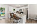 Bright kitchen boasts white cabinetry, stainless steel appliances, granite countertops, and an island with bar seating at 2850 Winchester Dr, Cumming, GA 30041