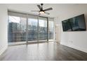 This bedroom features light gray walls and a ceiling fan. Sliding doors open to an urban balcony view at 1080 Peachtree Ne St # 804, Atlanta, GA 30309