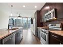 Modern kitchen includes an island with granite counters and stainless steel appliances with dark wood cabinets at 1080 Peachtree Ne St # 804, Atlanta, GA 30309