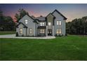 Beautiful modern home at dusk with a lush green lawn and black framed windows at 4292 Sardis Church Rd, Buford, GA 30519