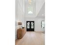 Elegant foyer featuring a grand two-story entrance with a chandelier and light wood floors at 4292 Sardis Church Rd, Buford, GA 30519
